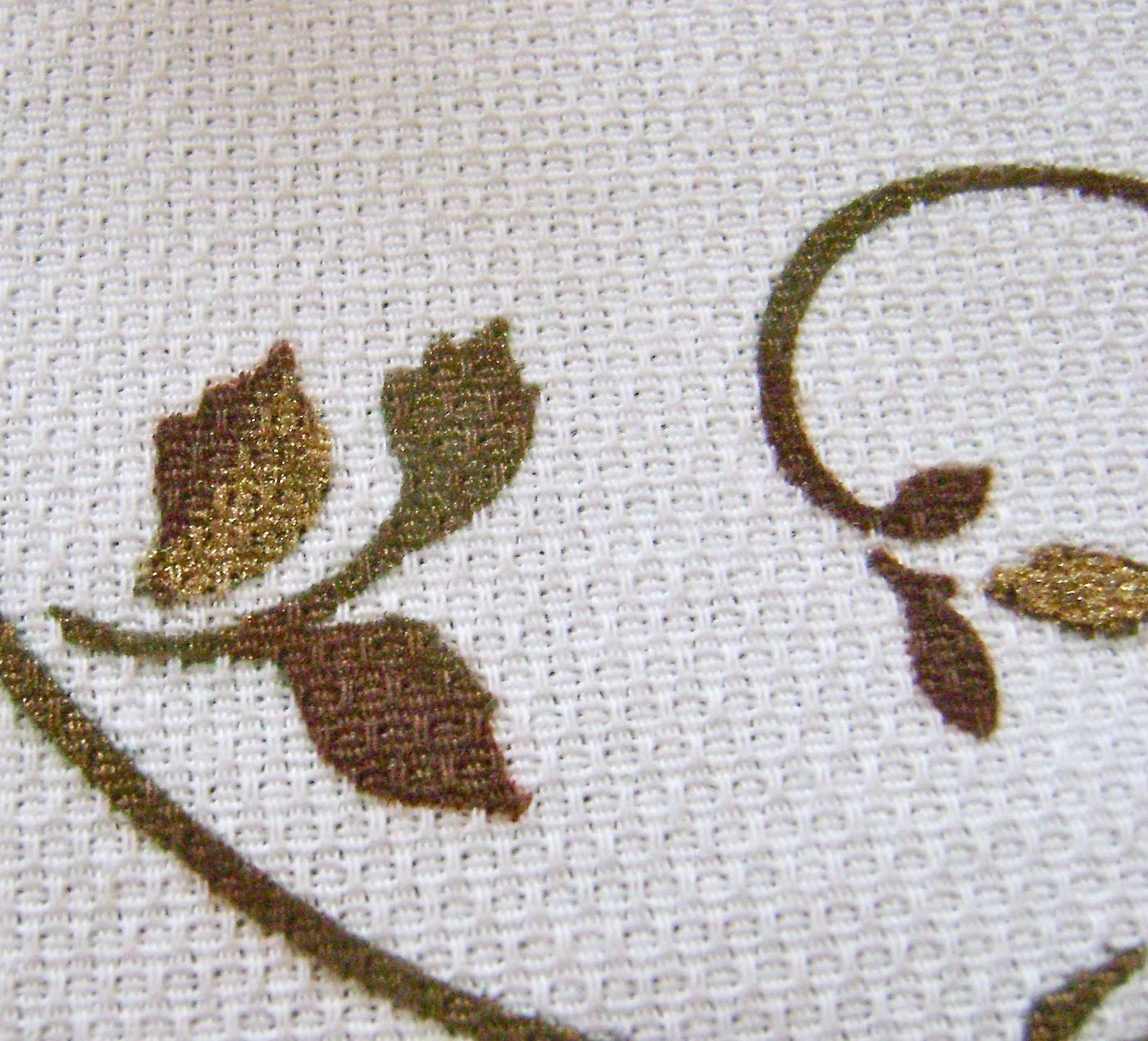 step 13 - Finish the runner by applying gold paint to some of the leaves and stems using a brush. Layer the decorative runner on top of the burlap runner and arrange them on the table.