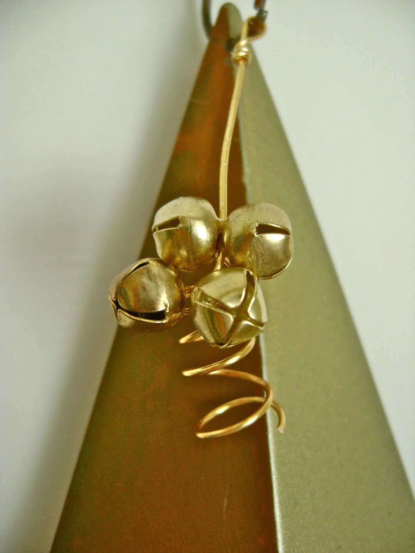 step 13 - Attach the bell’s wire to the wire ring and twist the ends to secure it in place.