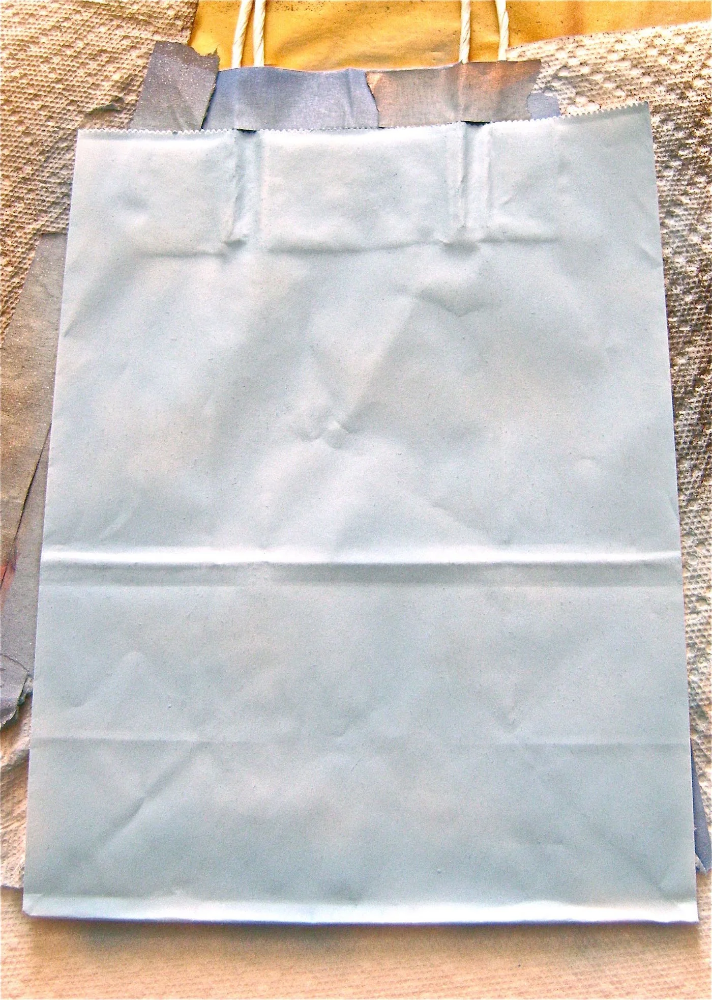 step 7 - Cut the corner of the Blue Suede Shoes pouch and pour half into an airbrush siphon bottle. Mix the blue paint with the white, a little at a time until you achieve the shade of blue you want. Spray the bag with the blue color. If necessary spray a second coat to create an even color.