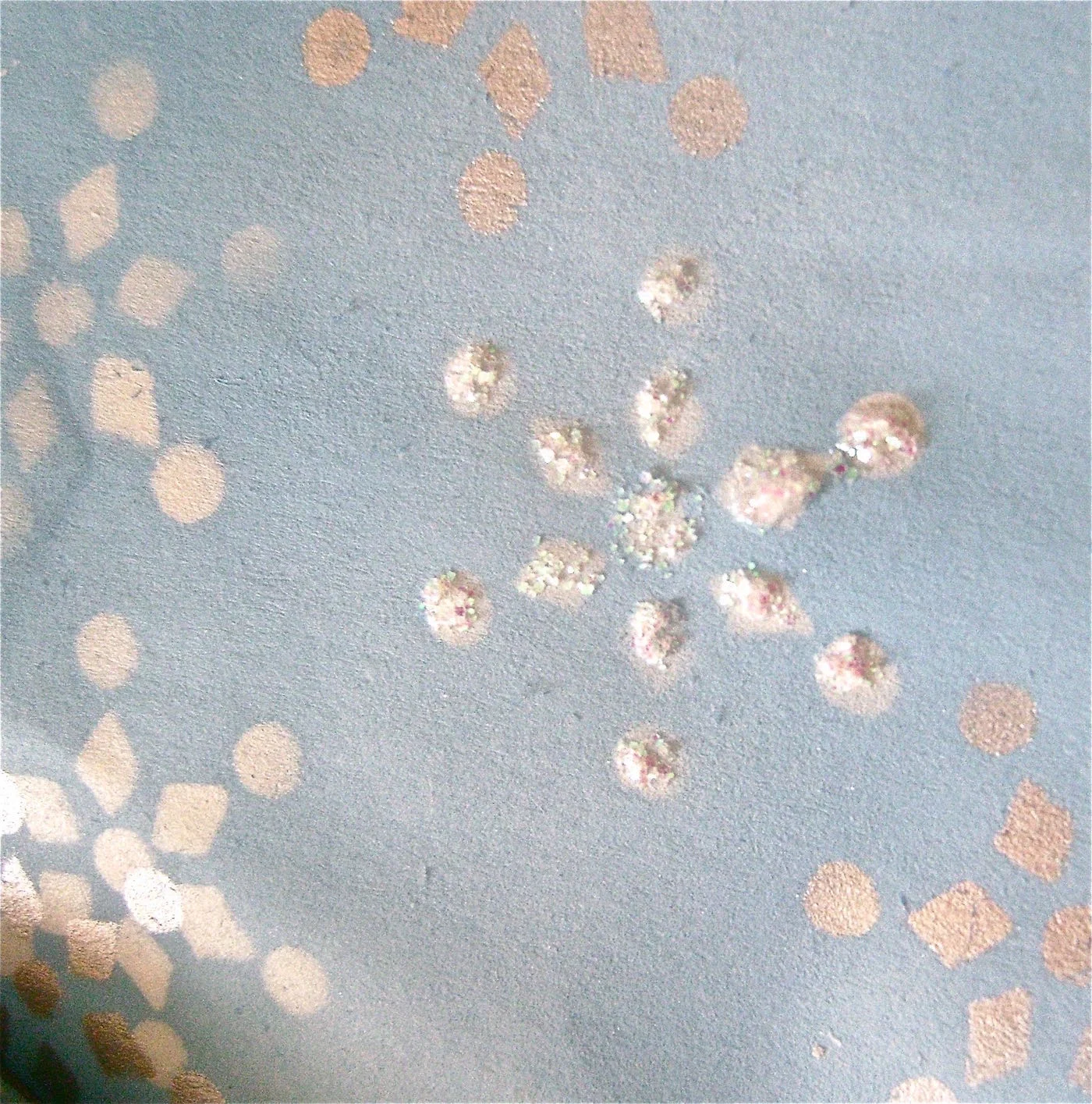 step 10 - Add shimmer to the bag by painting some of the white snowflakes with glitter glue. Apply it directly from the squeeze bottle, putting down dots on the flake shapes. It’s not necessary to outline each shape in detail.