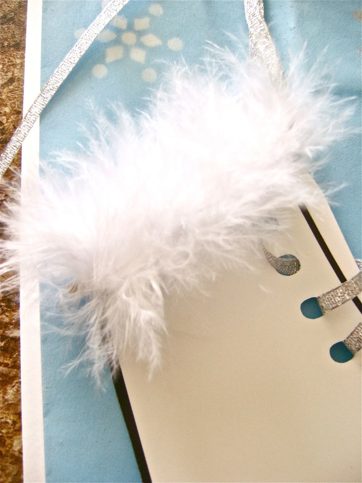 step 12 - Put down a bead of glue on the bag above the skate and attach a 2.25” strip of white boa to the glue.