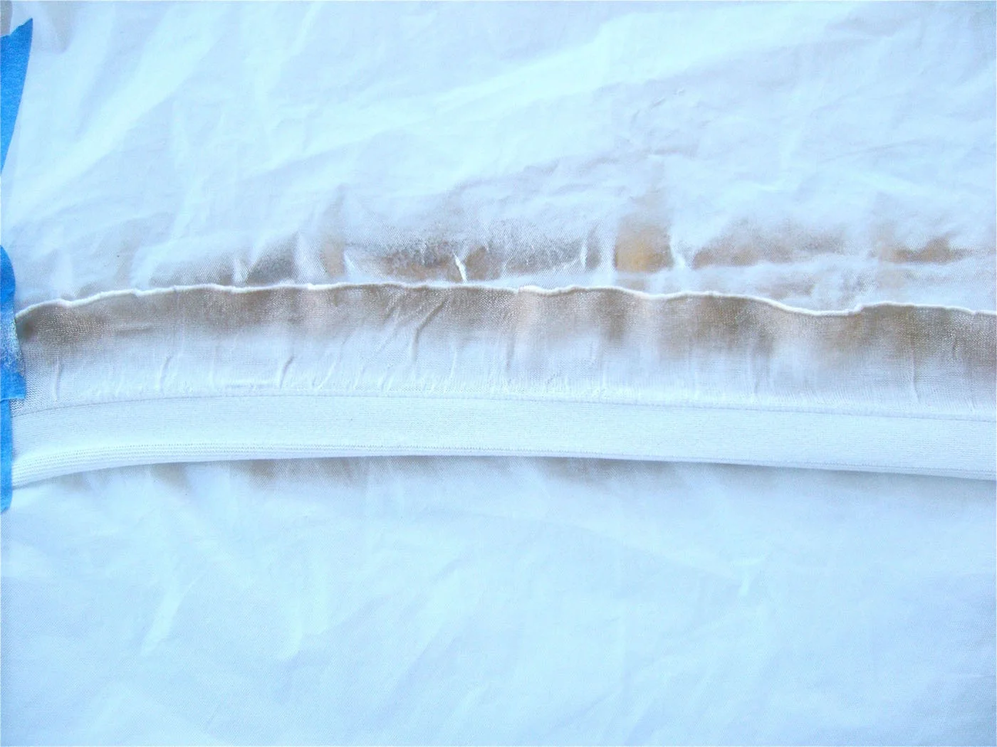 step 3 - Using a fine nozzle and light pressure, create a line across the edge of the ruffle with gold paint. Too much pressure from the airbrush will lift the delicate fabric. Drape the ruffles over a hanger to dry.