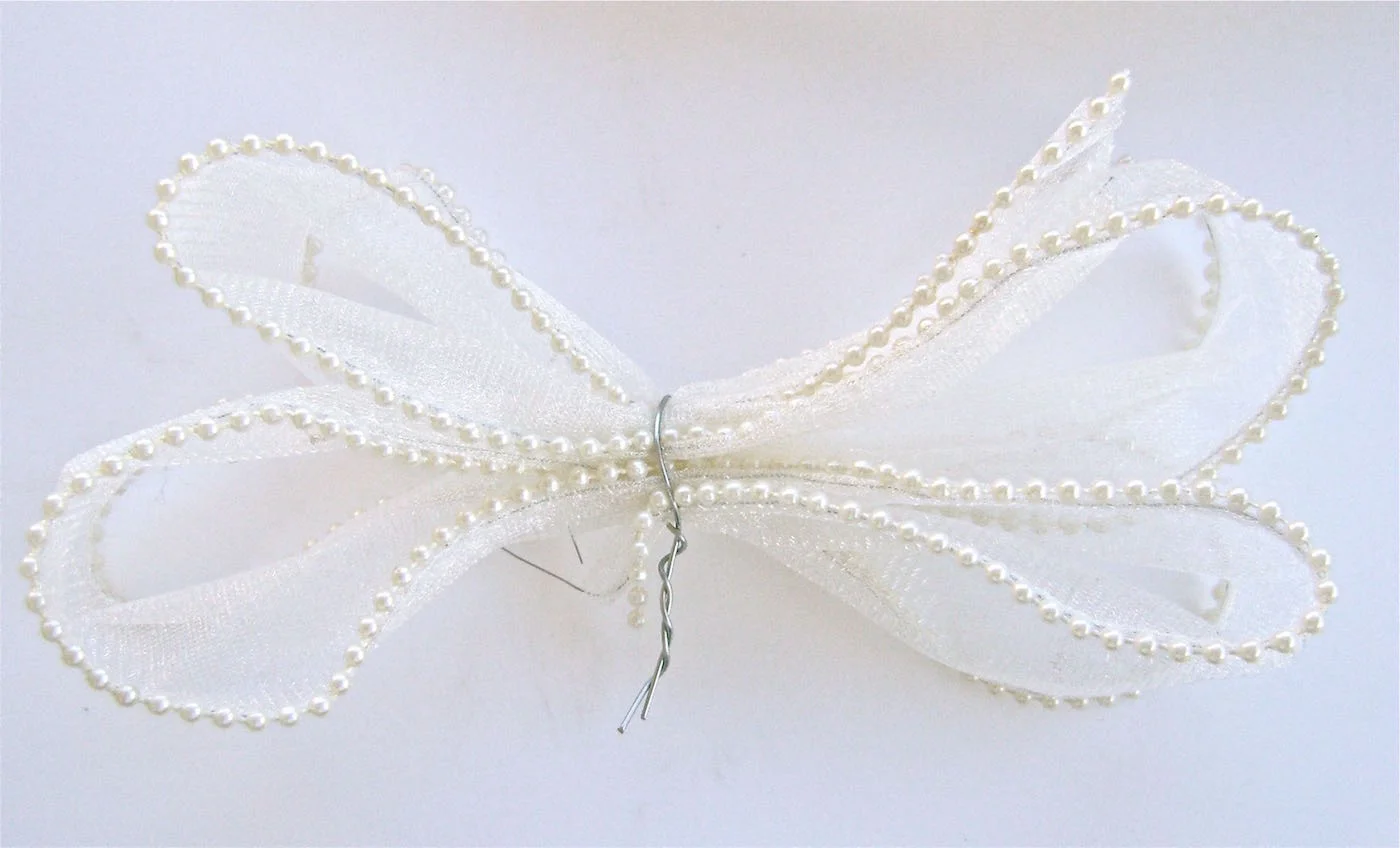 step 10 - Create the bow by making four loops with one piece of ribbon. Secure the bow with wire, twisting the ends together. Leave a 2” tail of ribbon.