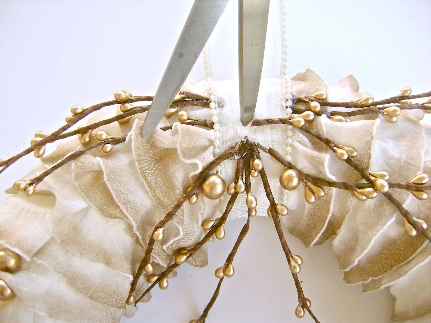 step 11 - Using the point of a scissor blade, poke a hole through the ribbon and in the top center of the wreath.