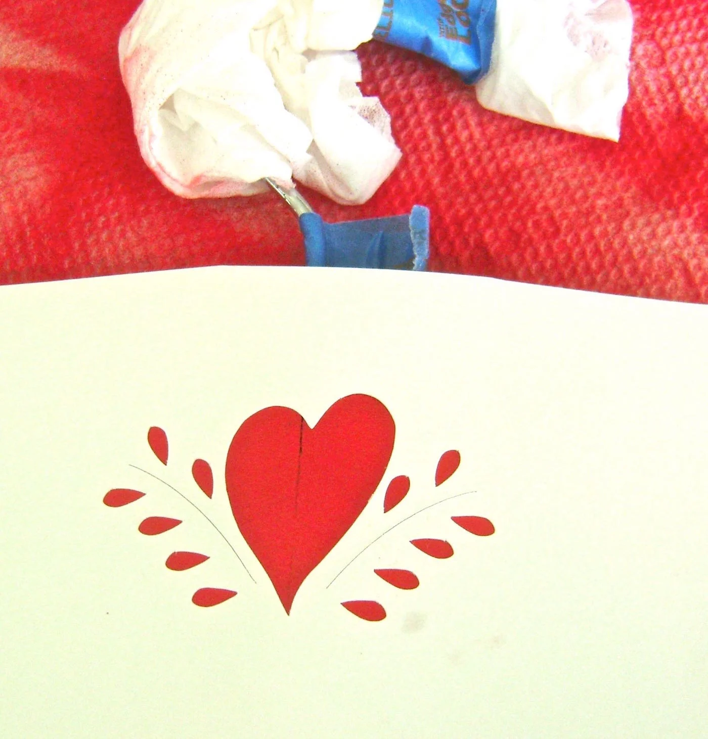 step 5 - Stick the heart stencil on the center of the hanger. Airbrush it with white paint.