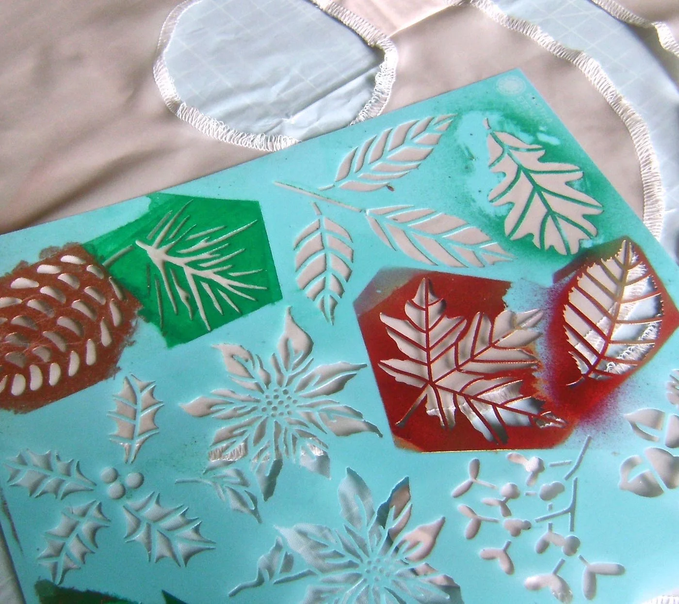 step 8 - Apply adhesive to the back of only the leaf stencils you will use. Plan your leaf style and color placement. Mask off your first leaf stencil with painters tape. Airbrush it with your color choice. When dry, move it to a different area and airbrush it with another color. When you have as many of that leaf as you want in different colors, remove the tape and mask off a different style leaf on the stencil. Continue changing colors and leaf styles adding as many leaves as you like.