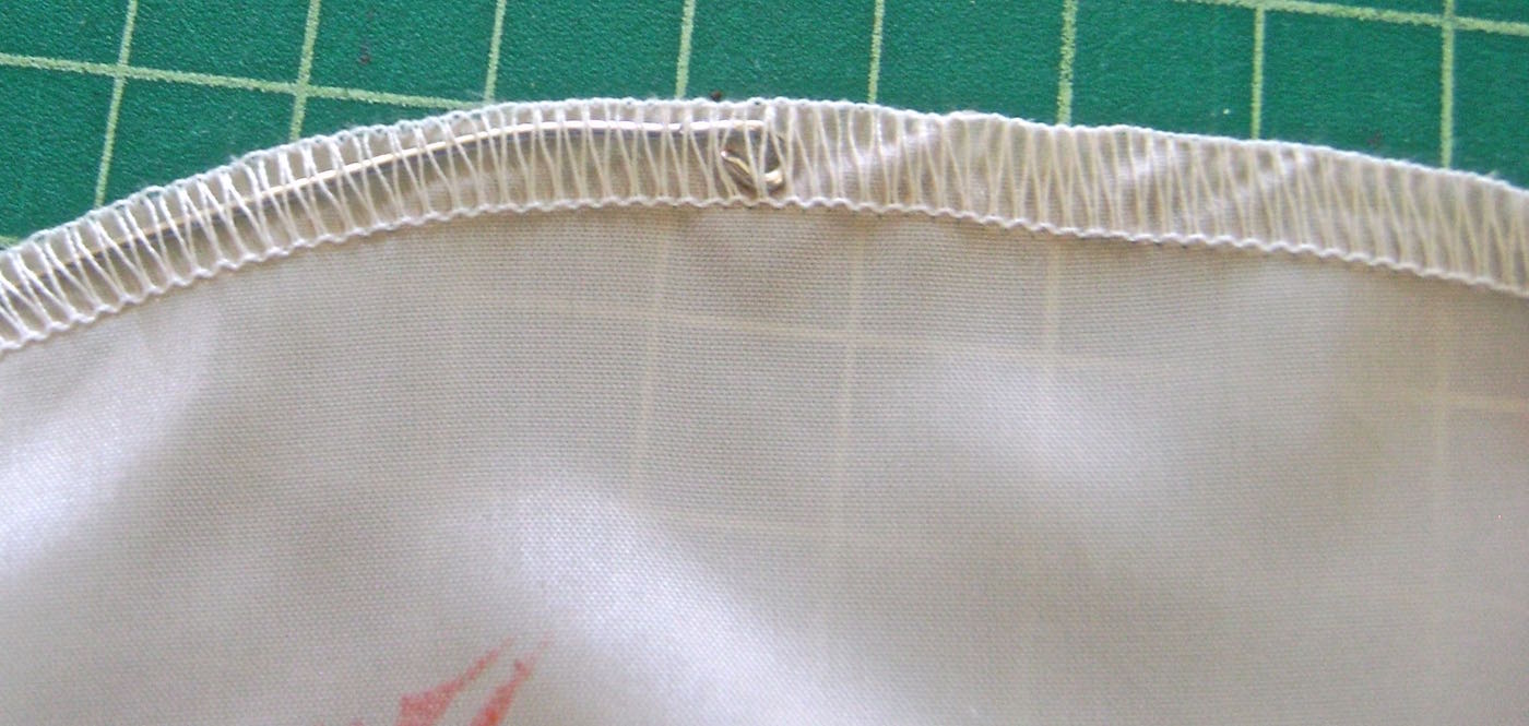 step 11 - Starting at the top facing, feed the loop through the serged or zigzagged stitching on the outer edge of the fabric, working through to the bottom facing. 