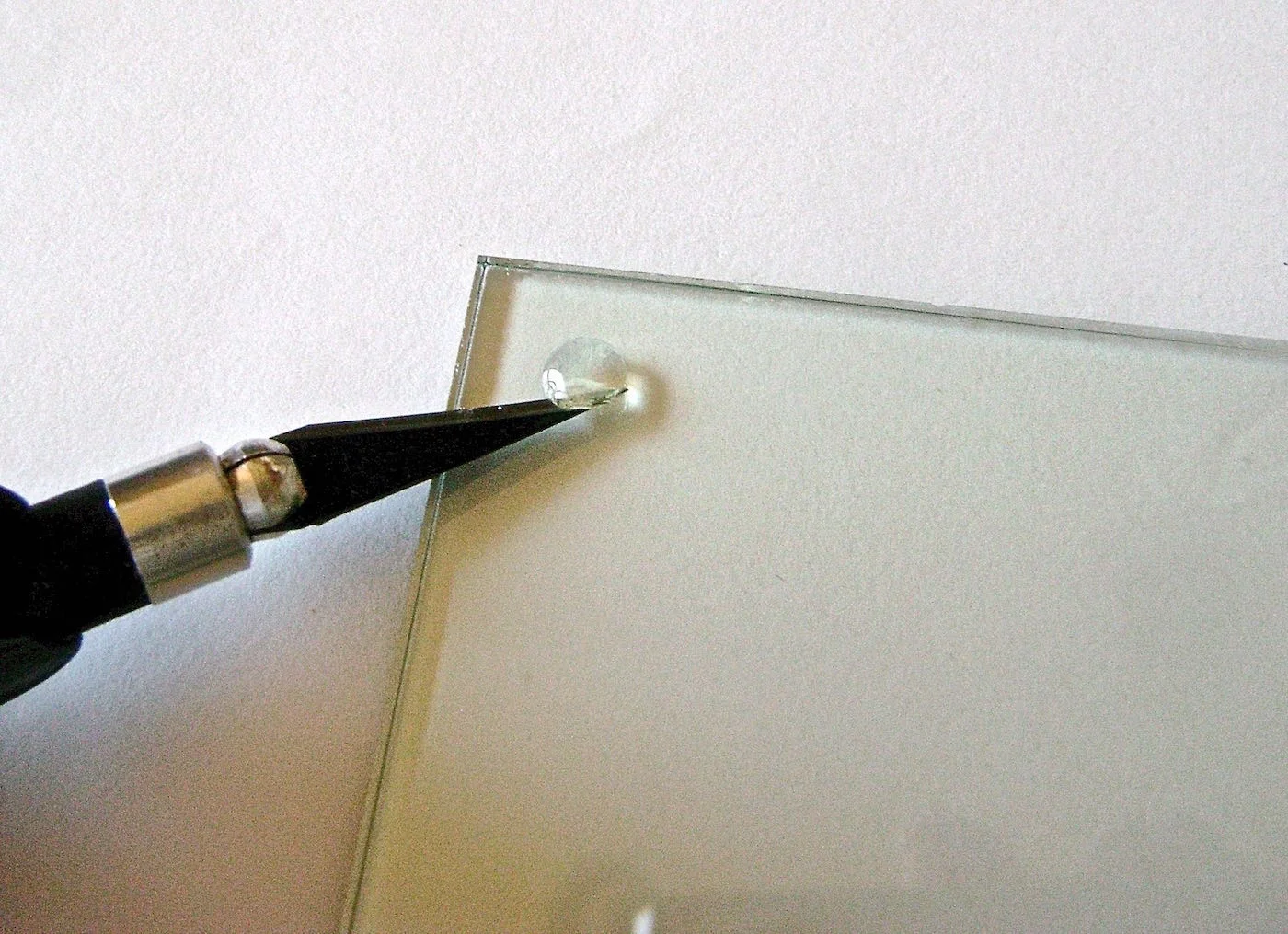 step 1 - Use a craft knife to remove the rubber feet on the four edges of the glass. Follow with rubbing alcohol to rid the glass of any remaining adhesive. Clean the entire glass with alcohol to wipe away fingerprints.