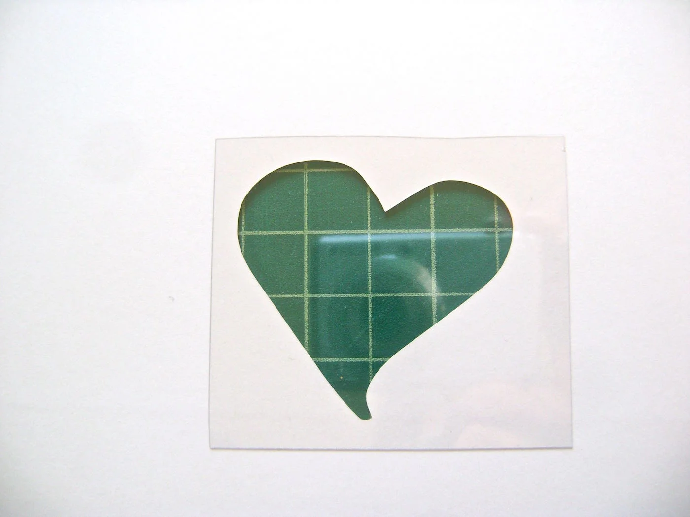 step 2 - Turn the card over. Cut out a clear plastic square slightly larger than the heart hole.