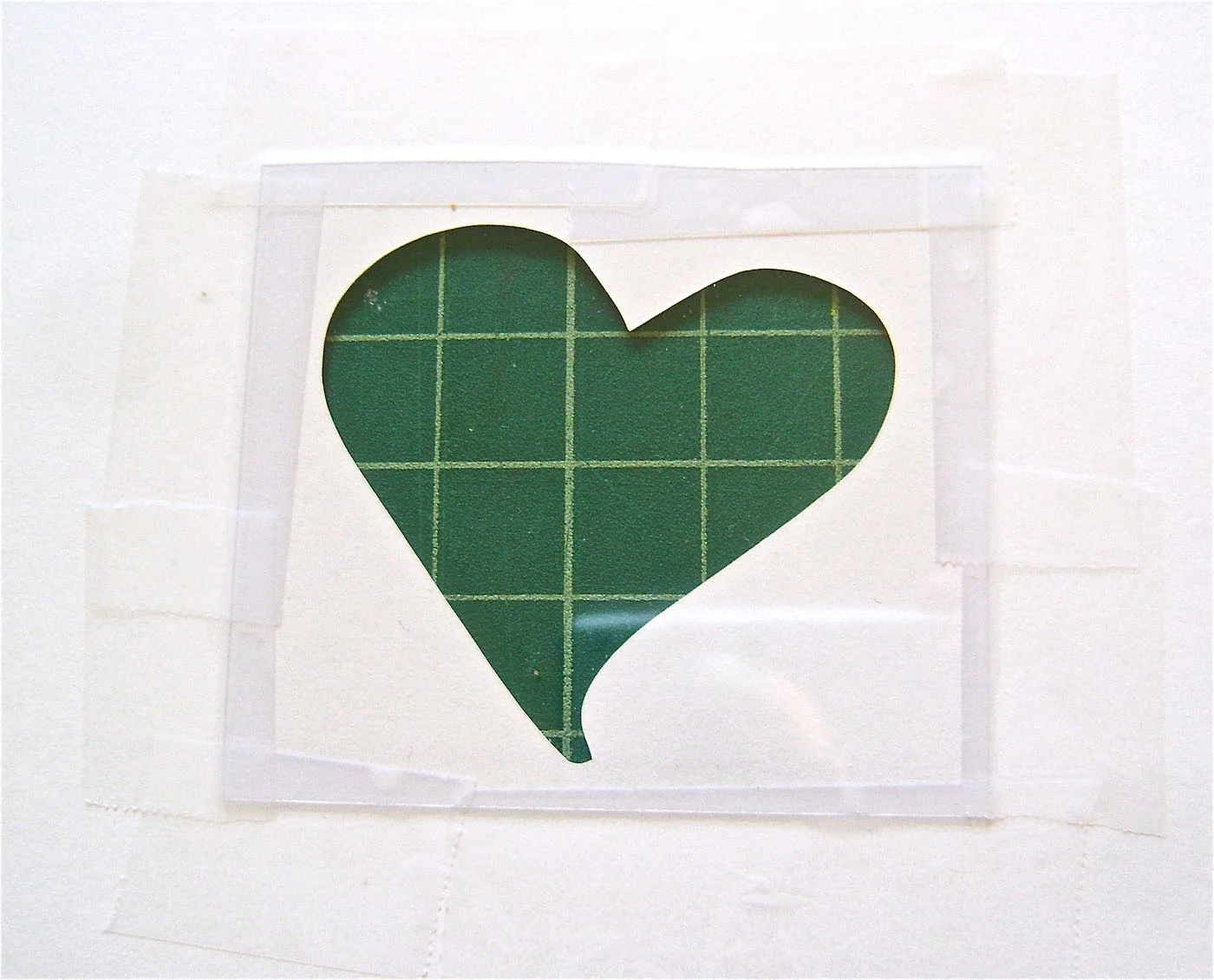 step 3 - Tape the plastic to the card on all four sides. Fold the card in half then open and lay it flat.