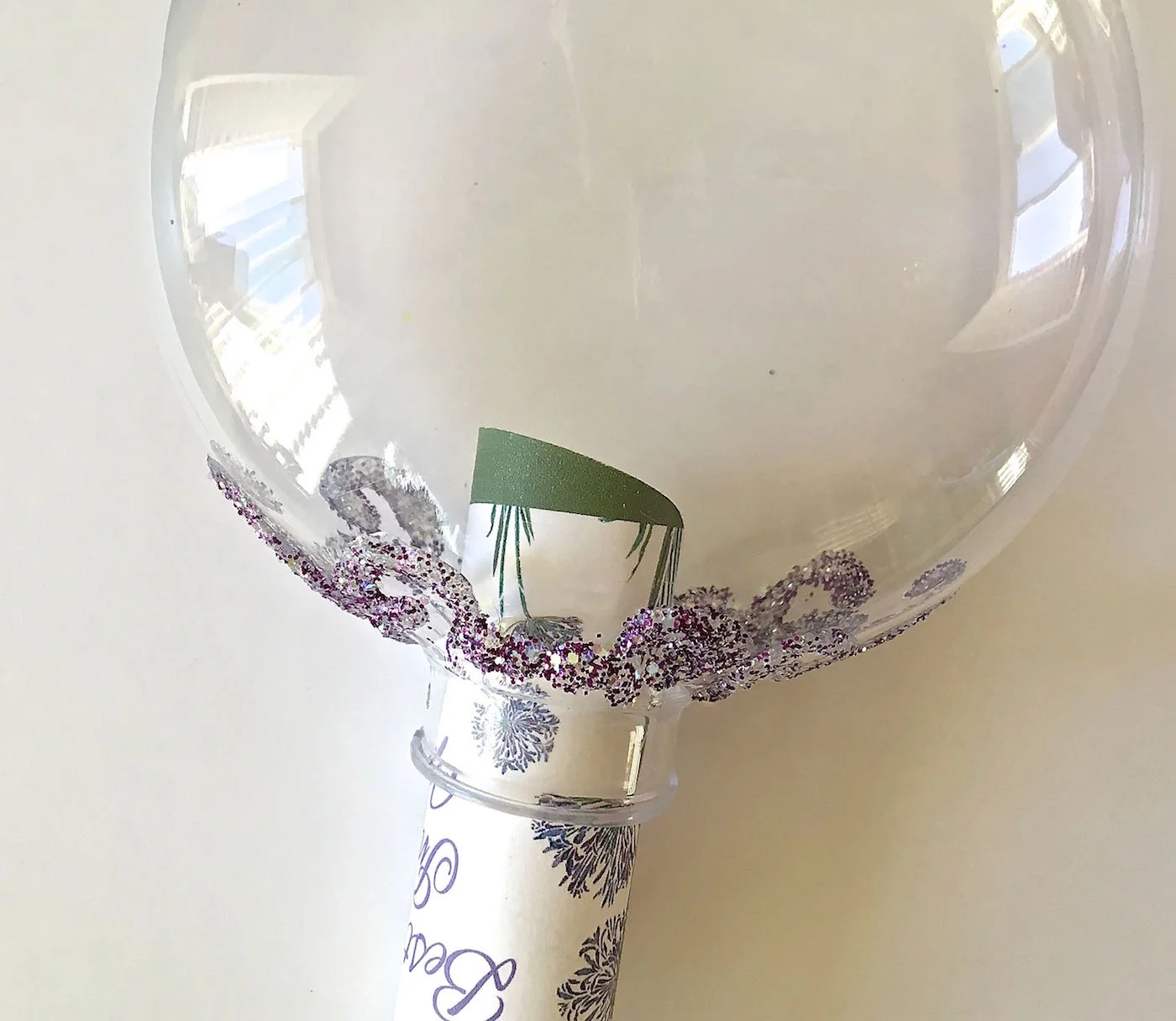 step 4 - Loosely roll the edges of the circle and insert the image into the ornament. Hold onto the wire. Use a rigid object like a fingernail file to press the card stock flat open inside.