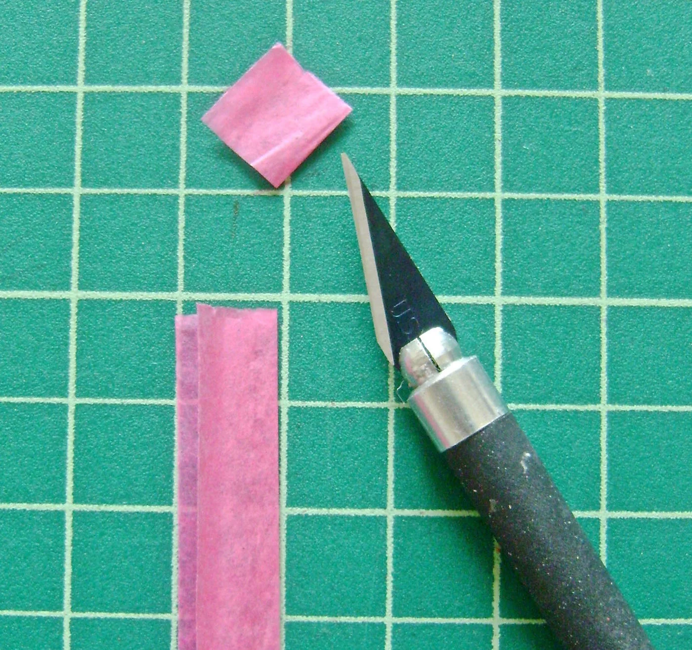 step 5 - Fold a strip of orange, pink, and white gift wrap tissue paper in half. Cut about 6 of each color to measure .50” square.