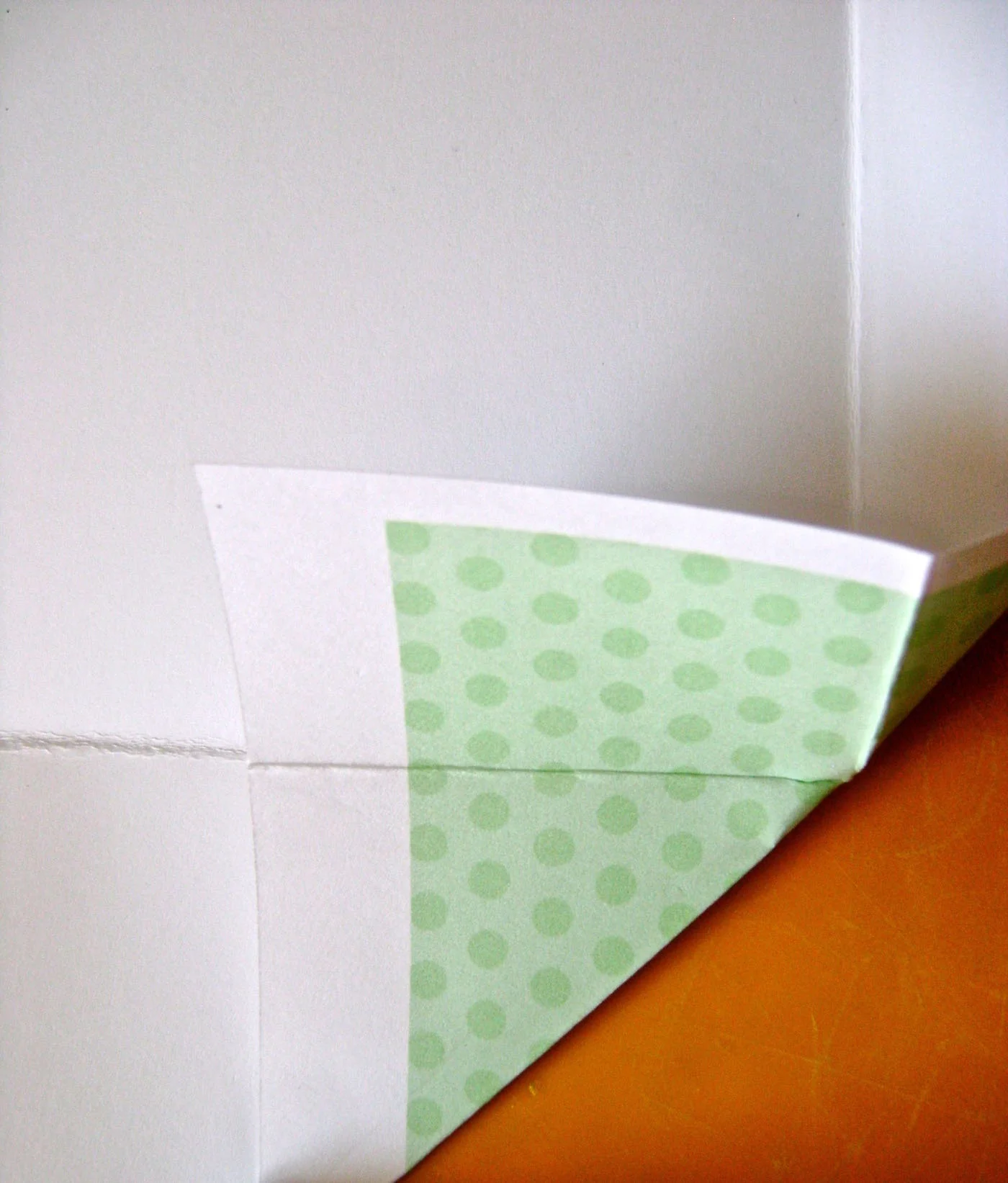 step 5 - Fold the bottom corners of the color pages by bringing the right vertical fold line in to meet the horizontal fold on the center section. Do the same on the left side and then the other color page.