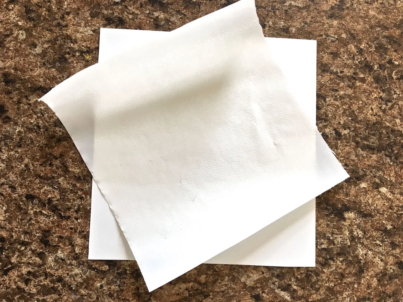 step 4 - Print out the word "Easter" on copy paper. Set aside. Cut a piece of card stock and a piece of Deco Foil Hot Melt Adhesive large enough to fit the word. Place the Hot Melt adhesive side down on the card stock.