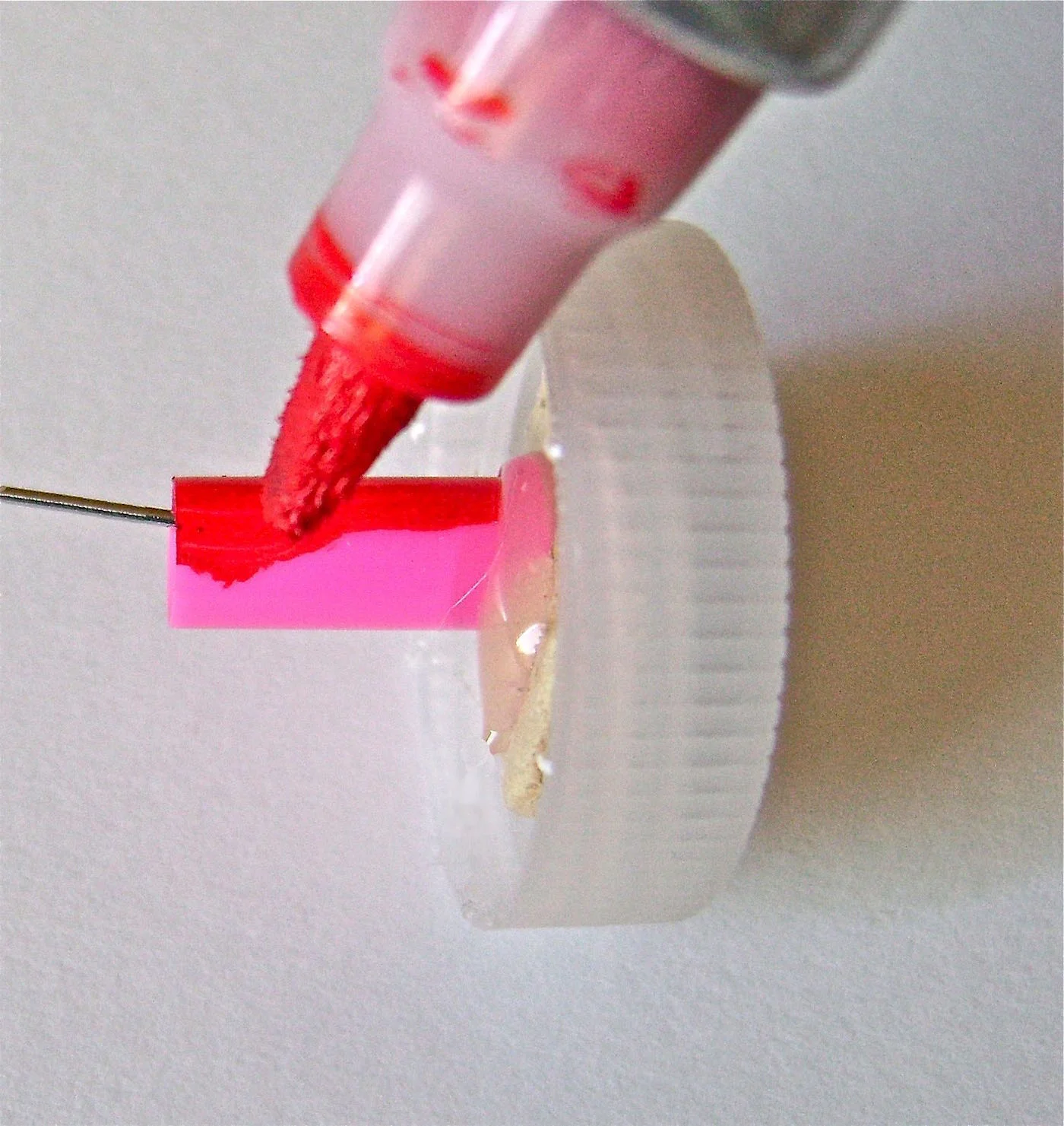 step 8 - Cut 1/2” from a plastic straw and slide it over the wire, gluing it to the cork. If you can’t find a red, white, or blue straw, you can color it with an enamel paint marker.