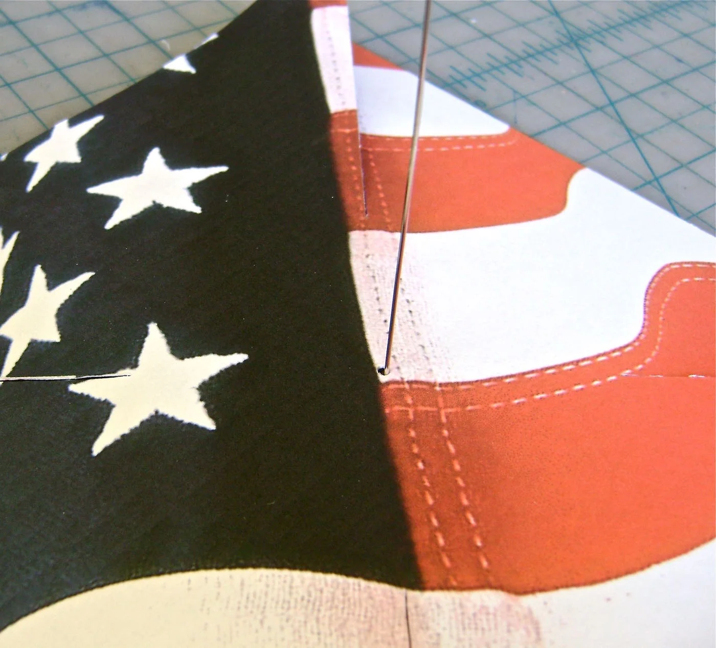 step 9 - When the glue is set in the cap, slip the wire through the center hole in the printed square. Bring up the corner pieces and slip the wire through the holes, one at a time.