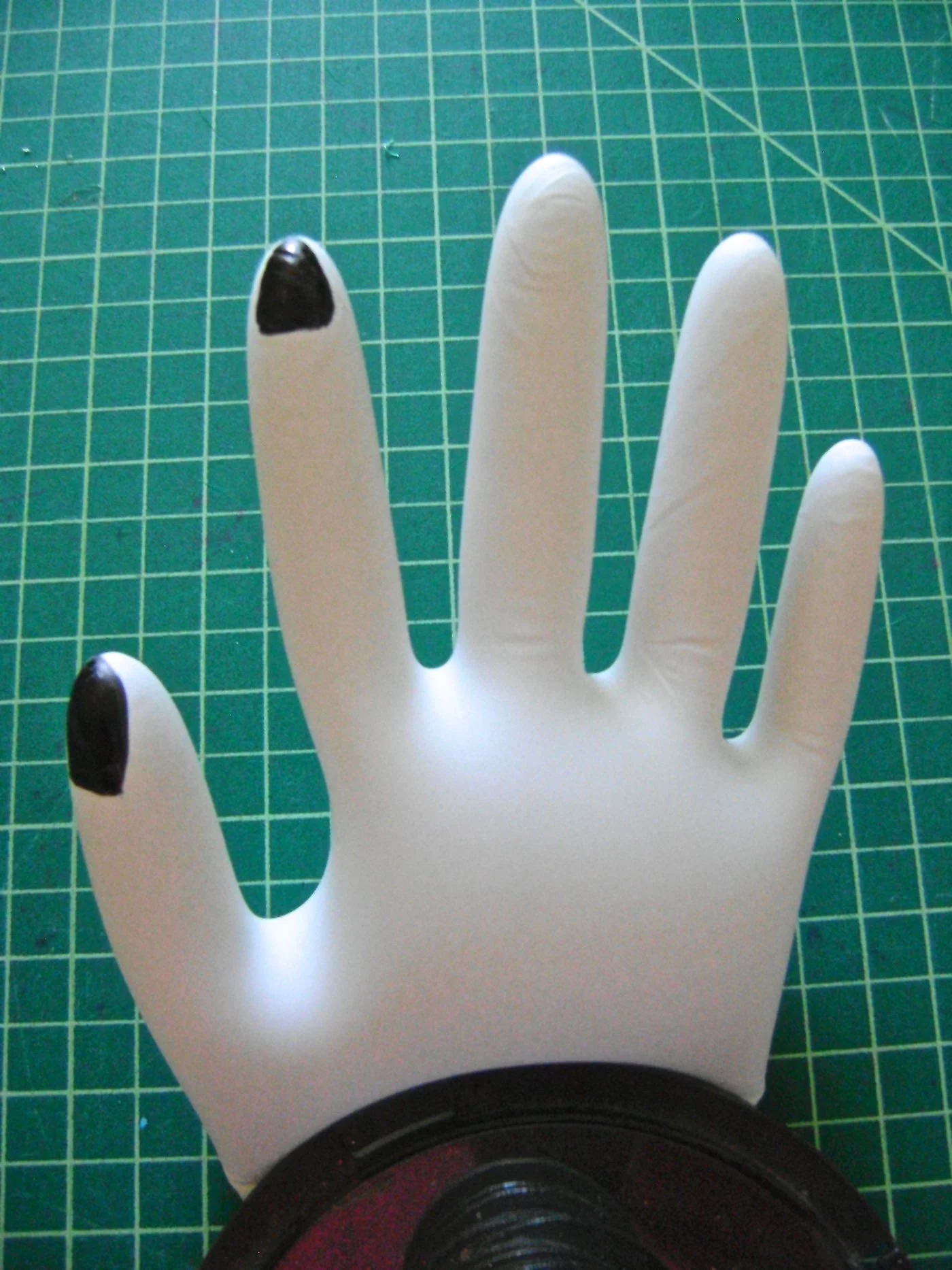 step 16 - To create the hands, blow air into plastic gloves and tie the ends in a knot. Lay a heavy object across the “wrist”. This will puff up the hand and make applying fingernails with a magic marker an easy job.