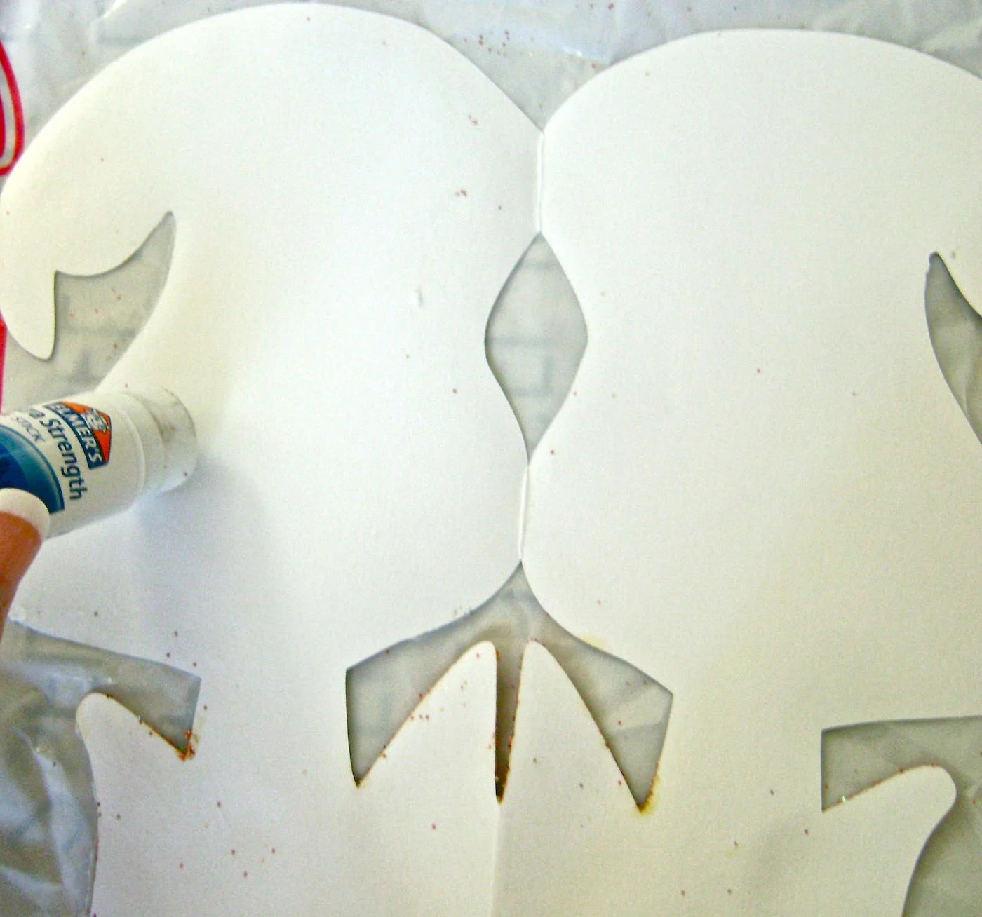 step 7 - Using a glue stick, run around the outer edge of one ghost on the blank side. Also apply glue along the fold. 