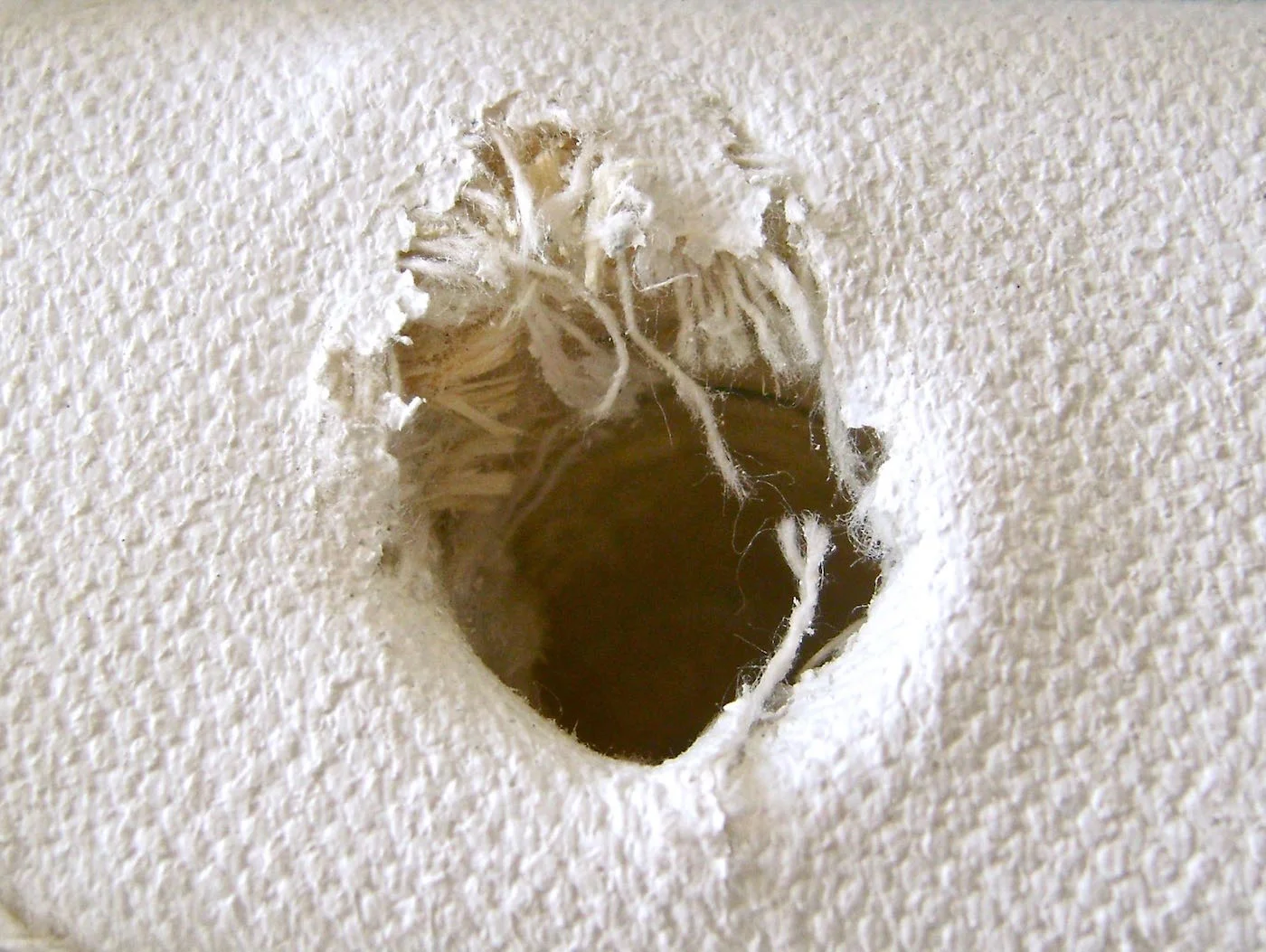 step 3 - Drill a hole in the top right of the canvas with a .75” drill bit. The hole should be 2 1/8” deep. The canvas edge will get chewed by the bit but it will be covered later.