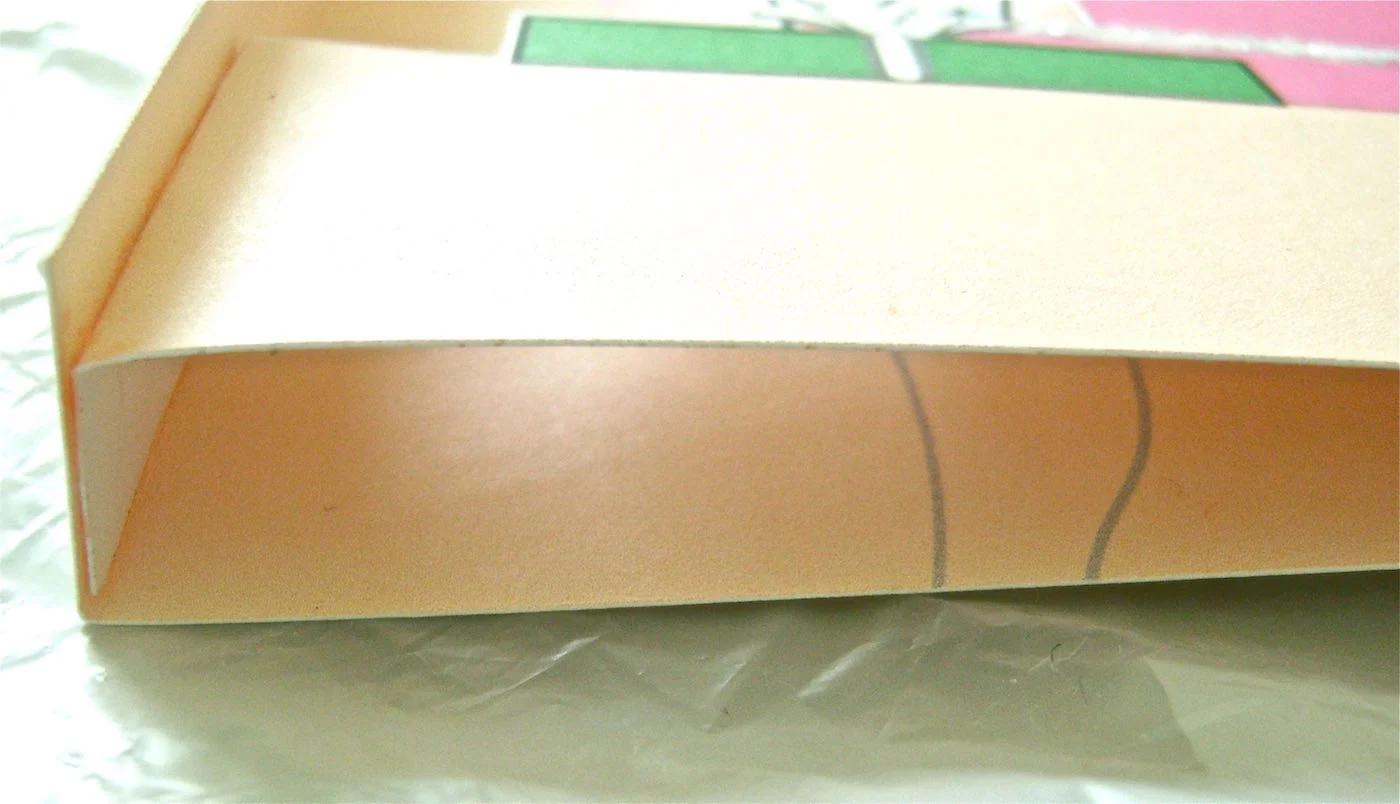 step 7 - Rub the colored side of the flaps of page 2 with a glue stick. Align the bottom card edges and press the flap against both side folds of page 3. Allow the glue to set.