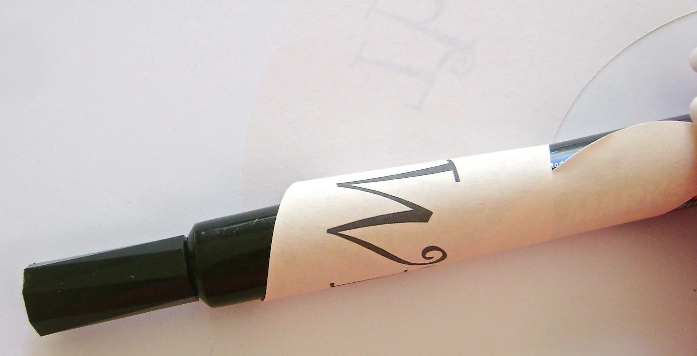 step 2 - Roll the bottom (the narrow end) of each layer around a large magic marker to create a slight curl in the paper. Only roll as far as the beginning of the word “With”.