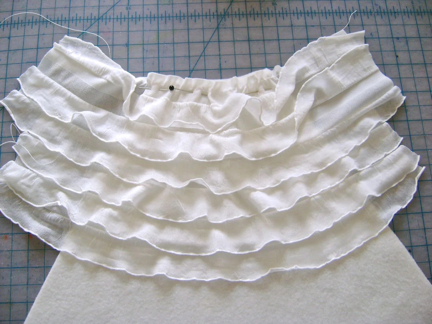 step 5 - Sew the next 13” strip onto the fleece with the bottom edge of the previous ruffle completely overlapping the margin of the new strip. The tails on each side should measure 2.25”.