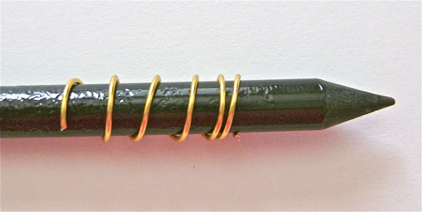 step 10 - Wrap a piece of gold wire around a slim pencil 5 times. Slip it off and cut off the ends. 