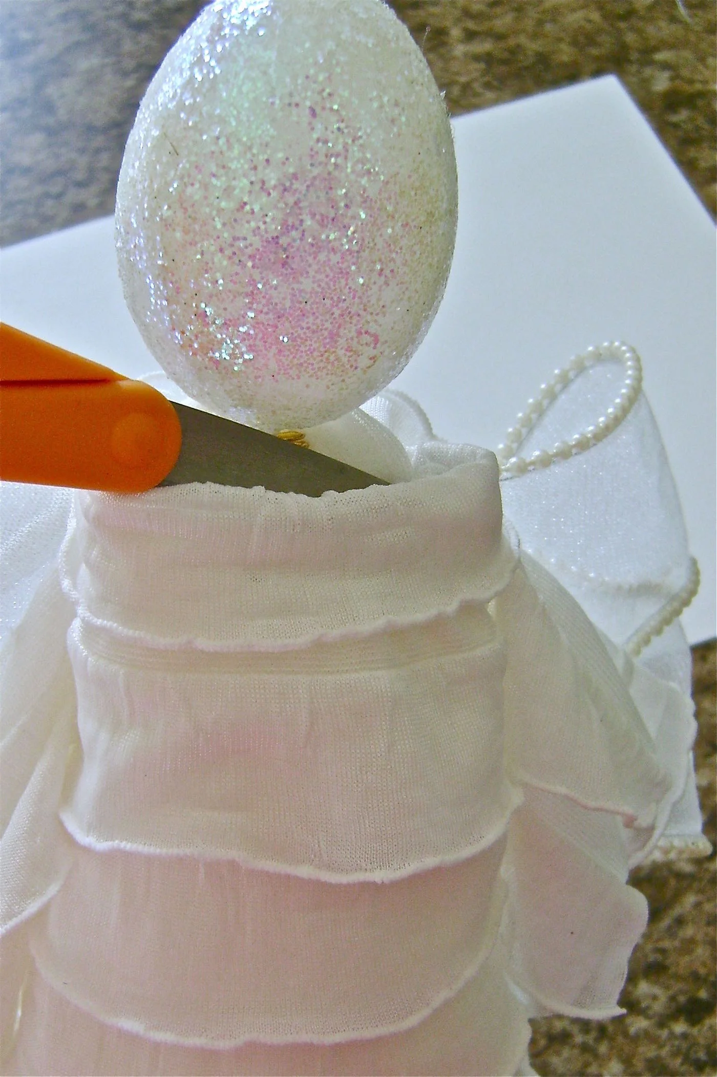 step 19 - Loosely wrap the tails of the collar round the neck and push them down between the fleece and the Styrofoam at the front. Hot glue the center front of fleece to the Styrofoam at the neck. Return the wings to their original position and reshape them as necessary.