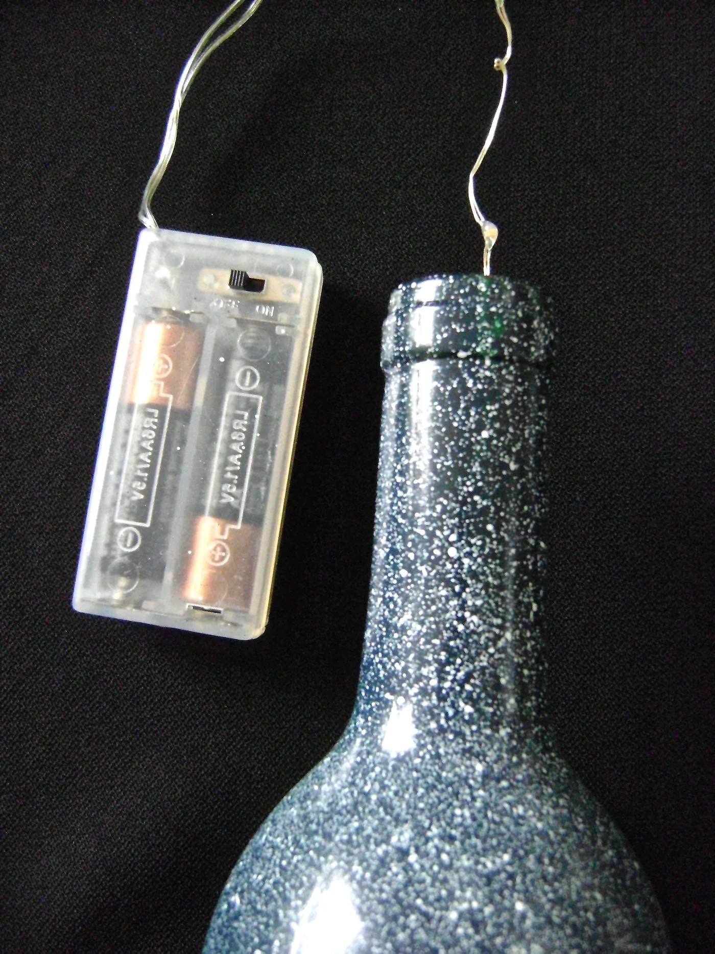 step 9 - Loosely stuff the lights into the bottle. Attach the battery pack to the neck of the bottle with a rubber band. The switch should be positioned so that it is easy to access.
