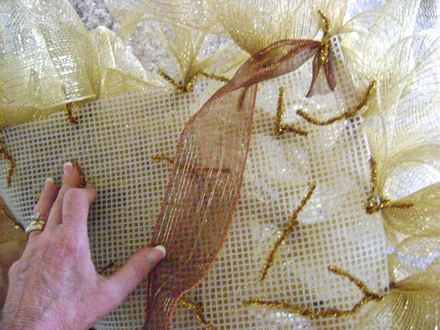 step 7 - Wrap a pipe cleaner around the end of the ribbon and attach it to the back corner of the canvas. 