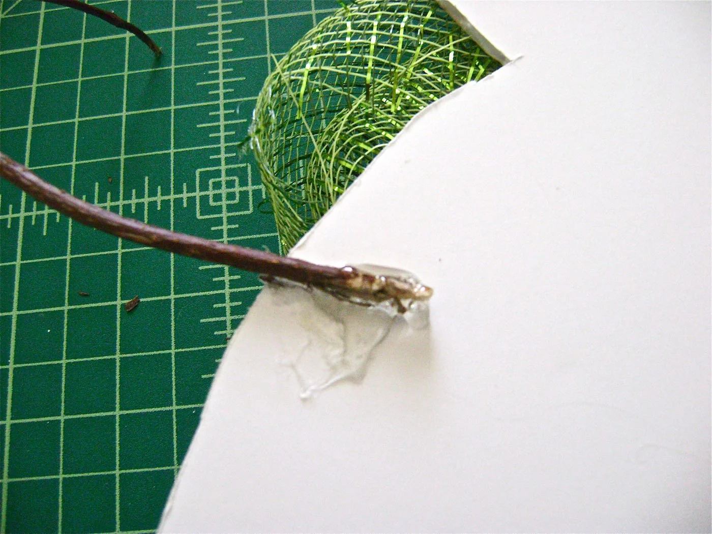 step 11 - Snowman Arms Search hedges or wooded areas for two matching branches to use as the snowman’s arms. Clean and trim the branches. Hot glue the larger ends of the branches to the snowman’s body on the back side of the foam board.