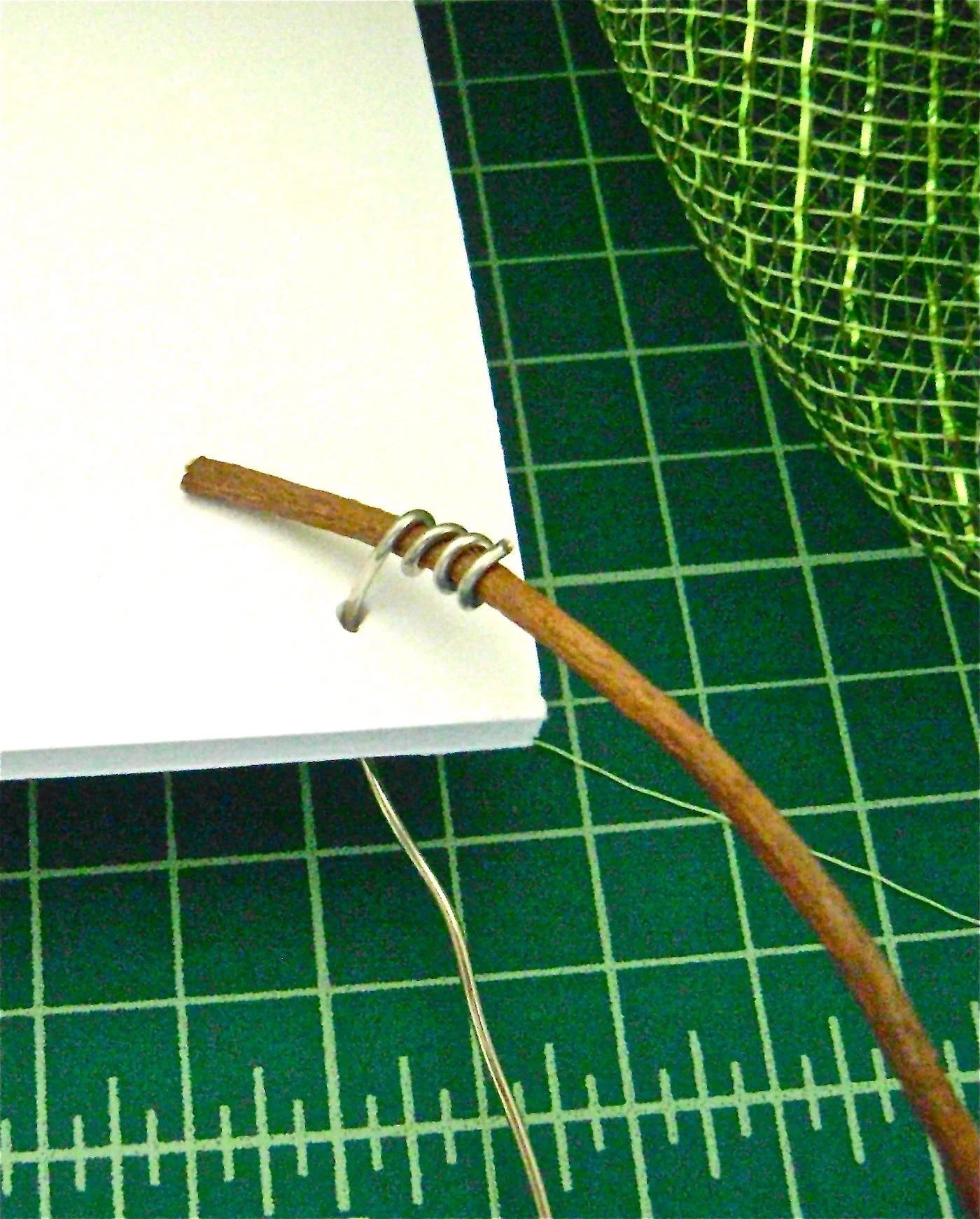 step 12 - Wrap jewelry wire around the thin ends of the branches. Pierce the bottom of the plaque corners with a needle. Push the wire ends through the holes and secure them on the back side.
