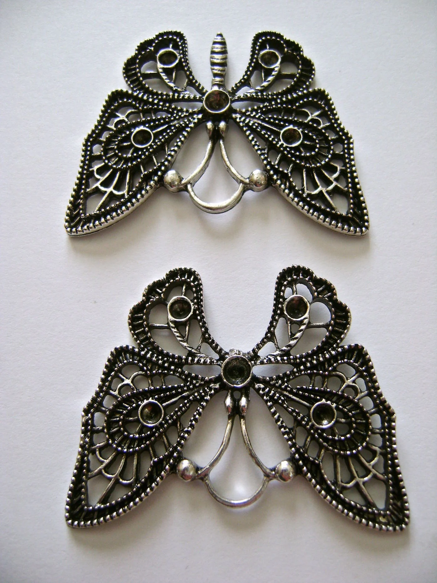 step 1 - Work with the butterfly upside down. The wire is soft enough to bend with your fingers but use needle nose pliers get in between the wings and gently break off the butterfly body.