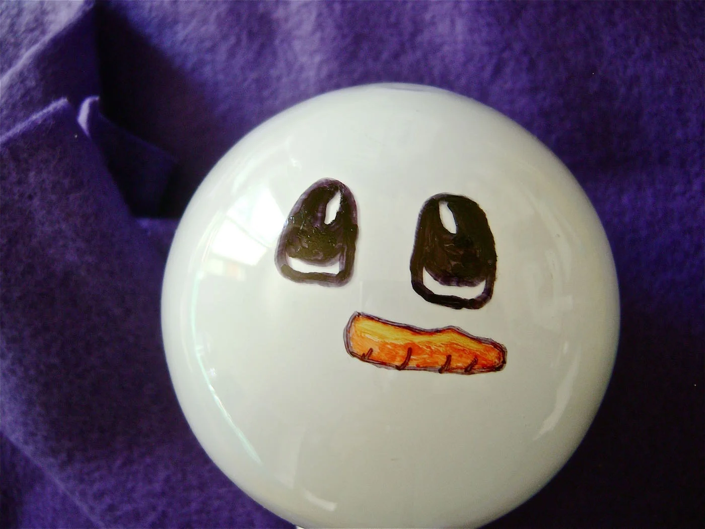 step 3 - Fill in the outline with an orange marker. Draw a yellow maker across the top of the nose to create definition. Add small black lines on the underside of the carrot.
