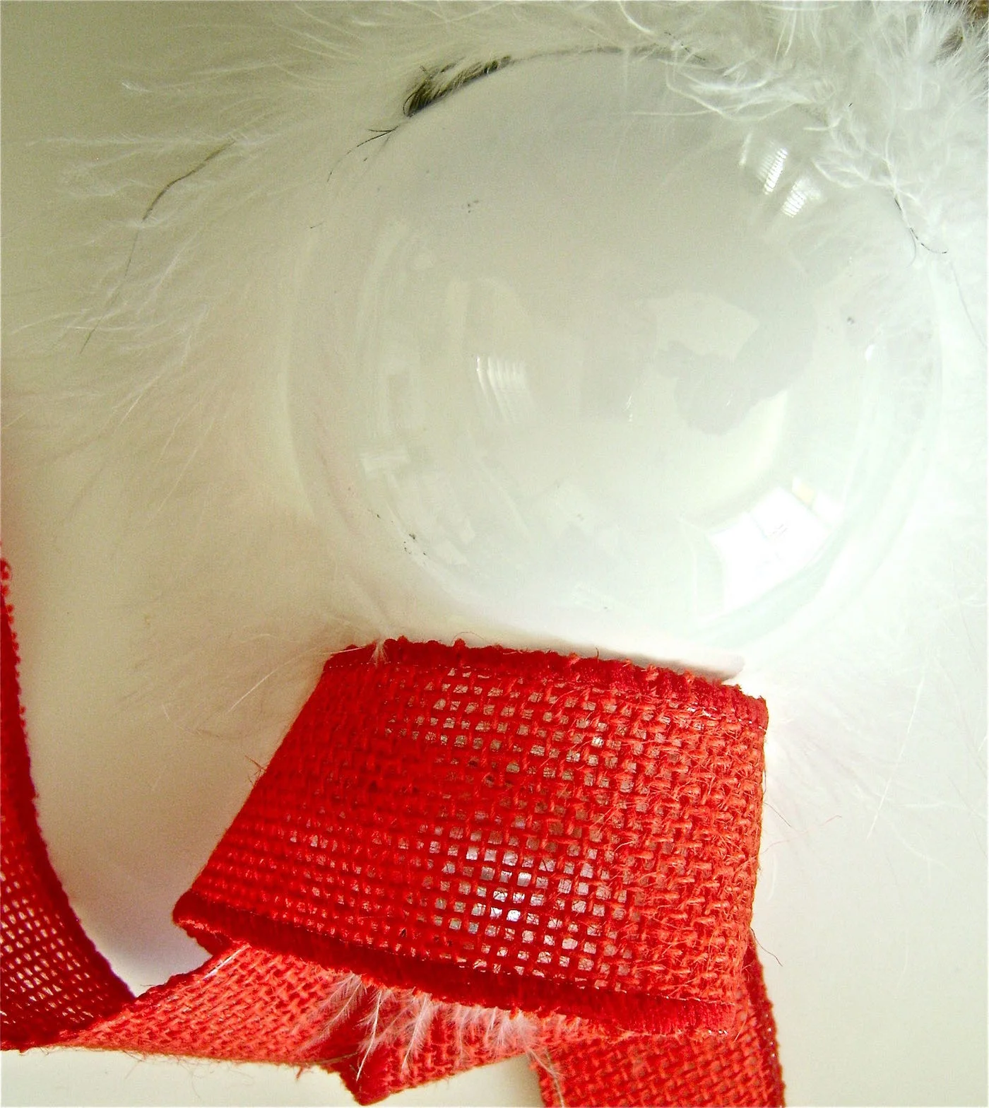 step 9 - Insert the bulb into the ribbon. Place hot glue on the center back of the ribbon edge and hold it against the center back of the bulb. Work your way around the scarf gluing it to the bulb.