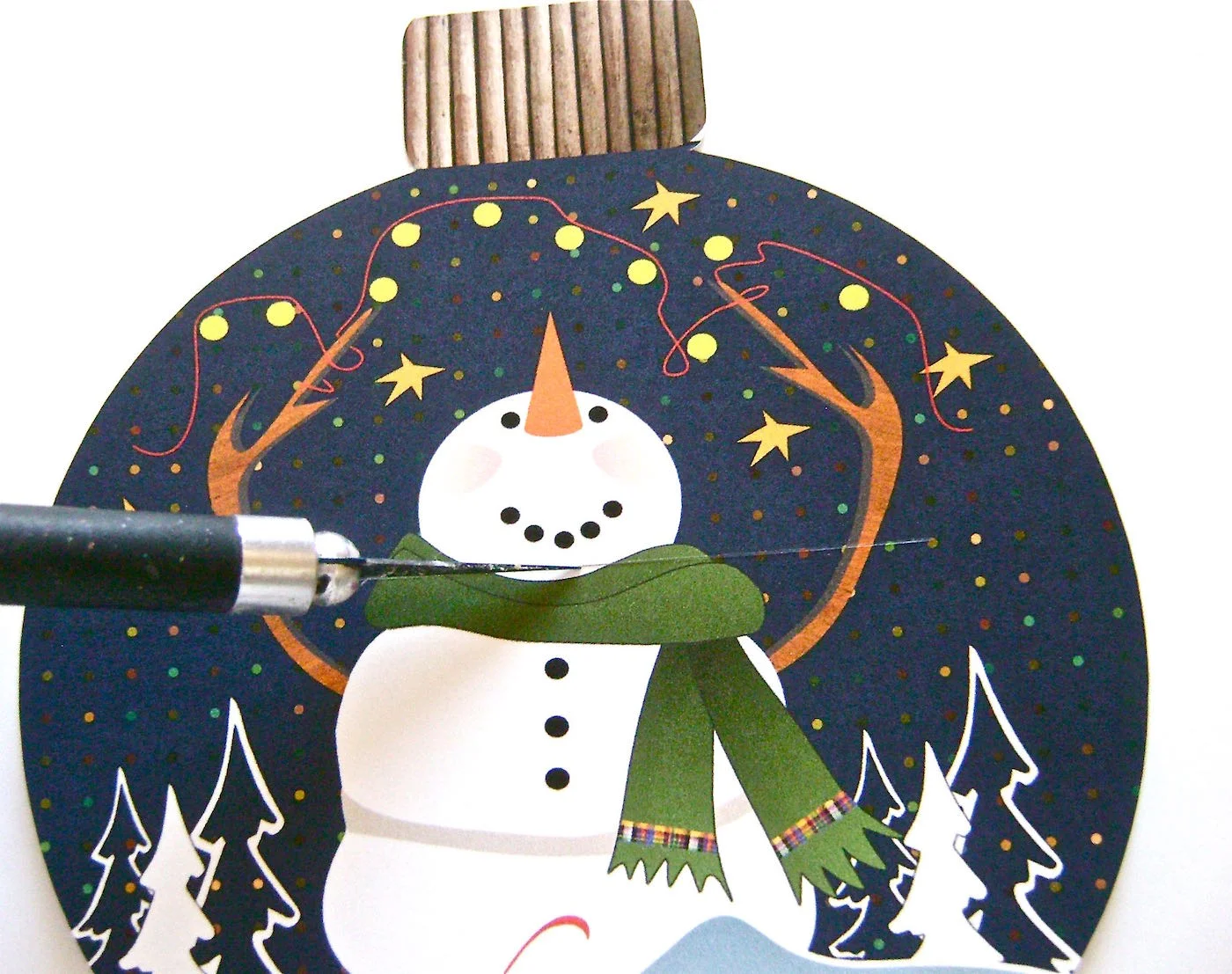 step 3 - With a craft knife, cut a 2.50” wide horizontal slit under the snowman’s smile to insert the card. Silhouette users skip this step.