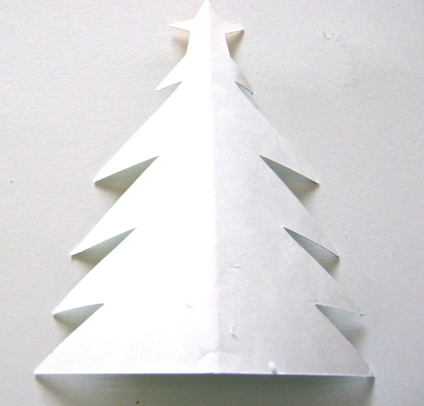 step 4 - Lay one tree flat on the work surface with the blank side facing you. Apply glue to the blank side center and out to all edges.