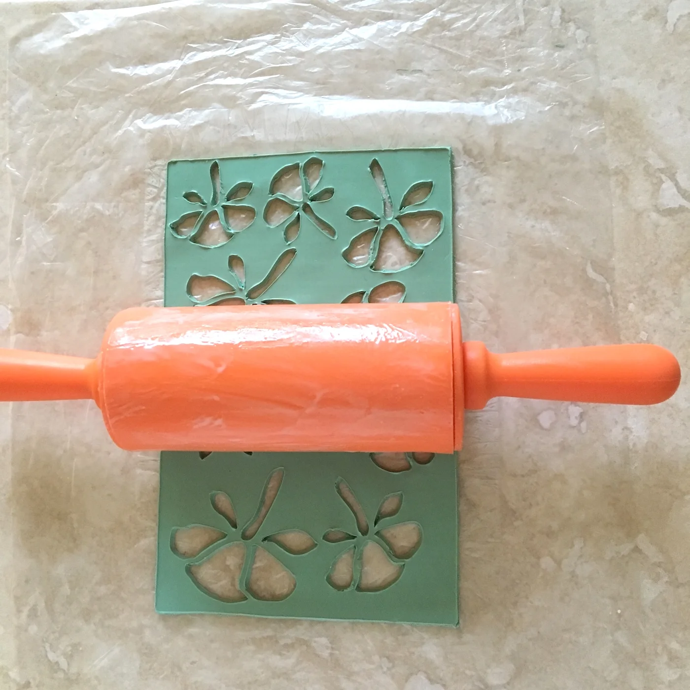 step 6 - Stack the largest red clay piece onto one of the green ones. Don’t match the shapes. Rotate the top piece so that the points of the red leaves fall between the green leaves.