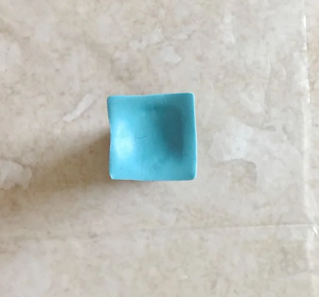 step 3 - Place one square on top of a .50” cutter with the sharp side up. Use your knuckle to gently form a dip in the center.