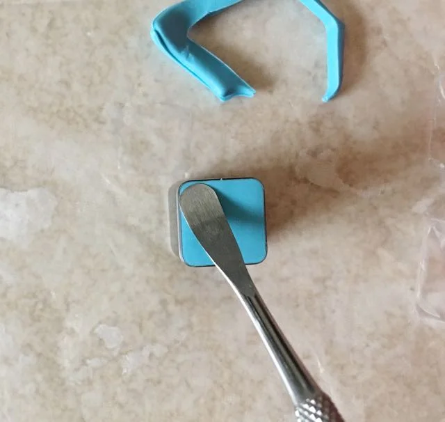step 6 - Use a sculpting tool to nudge the corners loose. One free, blow hard into the cutter to expel the bead.