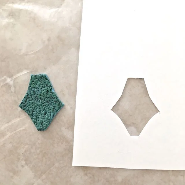step 12 - Cut The Clay Pieces With a craft knife, cut the earring shapes out of the card stock template creating a stencil. Lay the stencils on the textured clay and follow the shape with a craft knife to cut the pieces. Cut two “A” shapes and four “B” shapes. Set the pieces aside.