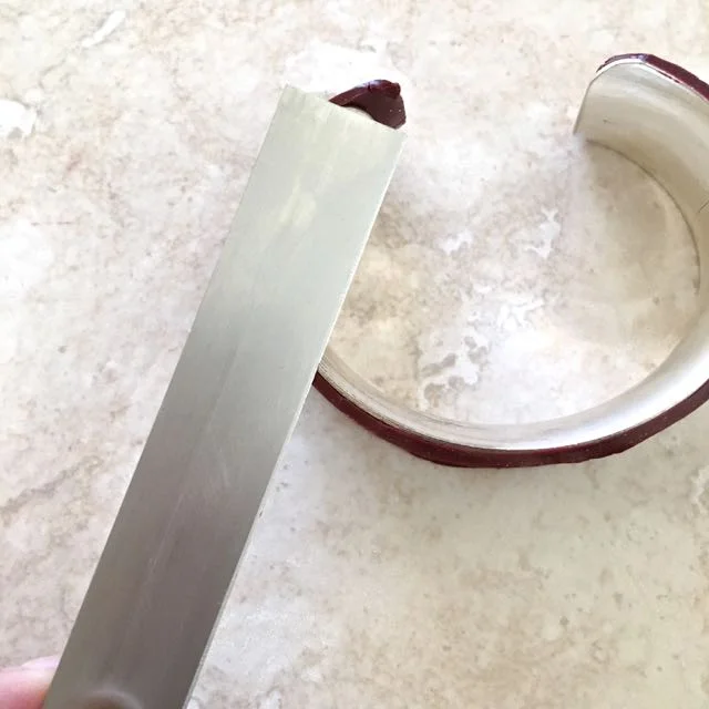 step 16 - Run a tissue blade flat along the metal cuff edges to trim away excess clay.