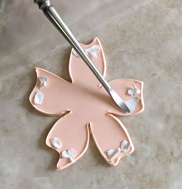 step 8 - Apply the bits to the edges of all the petals, spreading them like butter with the large and small smooth, oval shape tools. Spread out from the top center and down.