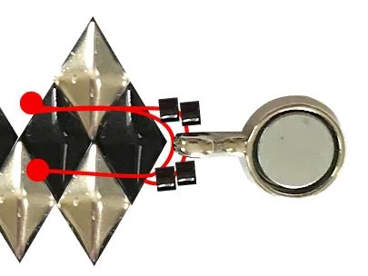 step 2 - Attach half of the clasp. You will pass through it a total of three times to secure the clasp. First, add two Delicas, the clasp, and two more Delicas. Bring the needle to the top hole of the end BDB. Pass through the second BDB. Create a half hitch-knot (red dot). Retrace your steps and move back through the delicas and the clasp, then the second two Delicas. Insert the needle into the bottom hole of the end BDB and then the second BDB. Create a half-hitch knot. Retrace your steps until the needle is back at the first half-hitch knot. Continue adding SDBs between the BDBs until you have 29 SDBs on the thread.