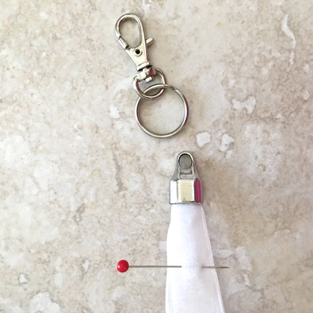 step 16 - When the glue is set, trim the ribbon edges and glue them into a large bead cap. Attach a swivel lobster clasp.