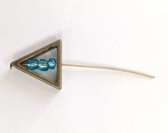 step 2 - Add three beads to the wire. Pass the wire through the straight edge of the triangle.