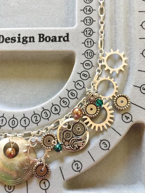 step 3 - Continue experimenting but only on one side of the board. Arrange smaller items like pearls, crystals and other elements with the major pieces.