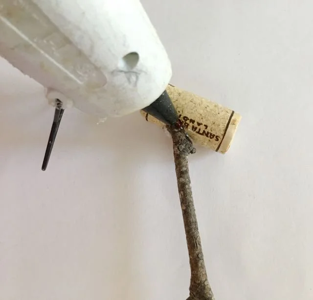 step 19 - Apply hot glue to the holes and insert the branches.