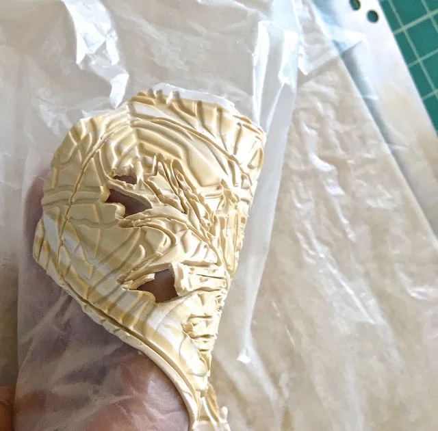 step 8 - SC – Drape the film-backed clay over your hand and push up on the cut lines. The cut pieces will pop out. Place deli film on the right side and remove the film from the backside.