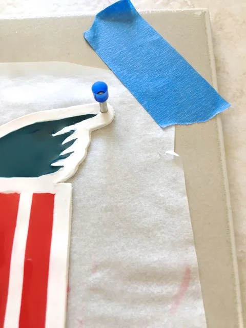 step 8 - If you plan to hang the finished clay, use a mini-hole cutter to pierce holes at the edge of both wings in the white clay area. After baking clay, thread stretchy cord through the holes to hang.